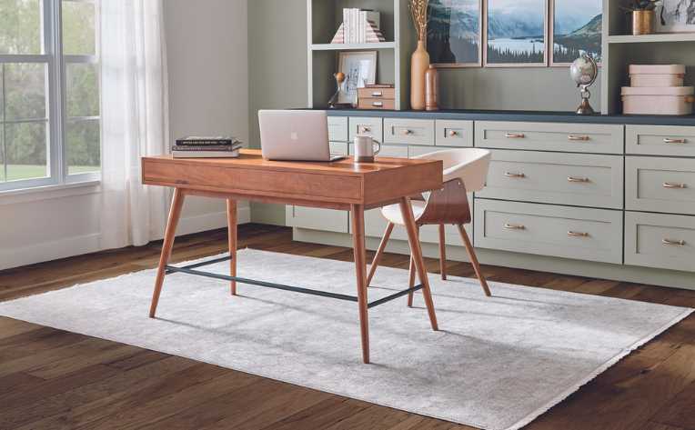 dark hardwood flooring in sage green modern home office with wood desk