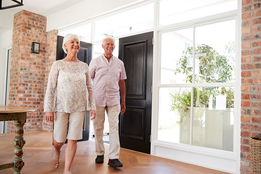 Senior couple walking in living room 